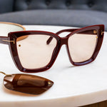Brown sunglasses with gold accents on a white surface and Chemistrie magnets installed