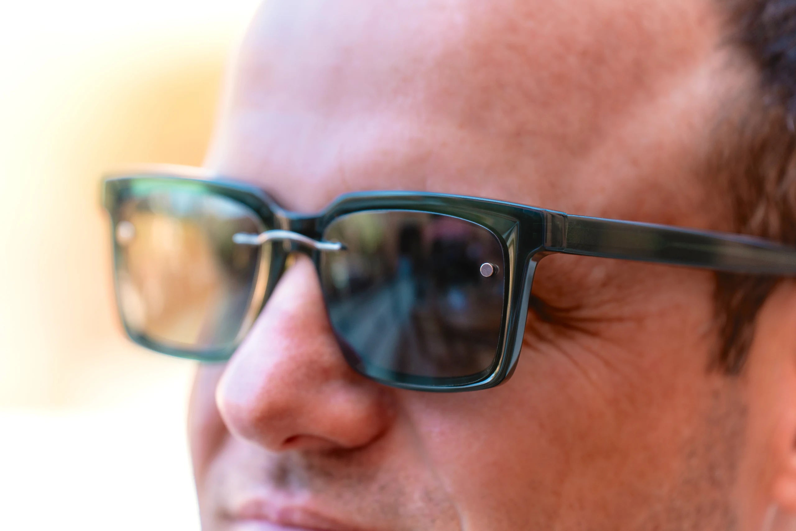 Close up of a dark clip attached to a pair of eyeglasses